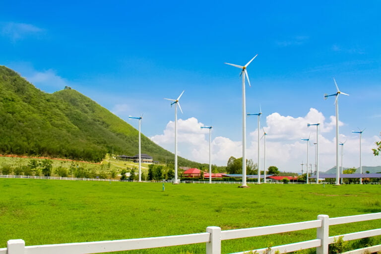 Elektrownia wiatrowa w otoczeniu g&oacute;r i zieleni